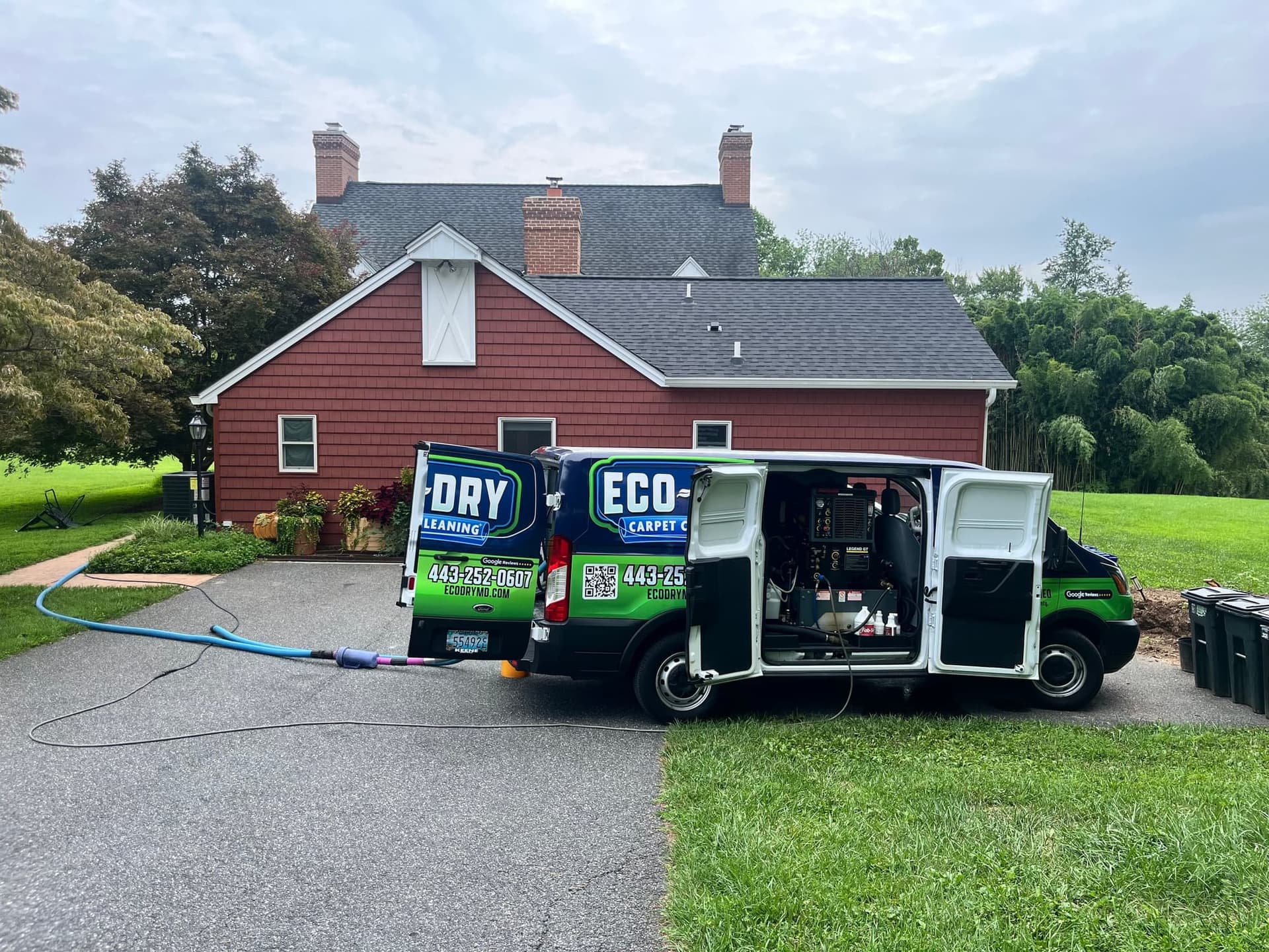 Open Eco-Dry van with hoses extending across a residential driveway