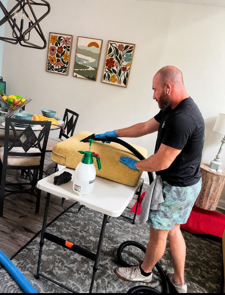 Technician using a hand tool on a yellow upholstered seat cushion on a work table